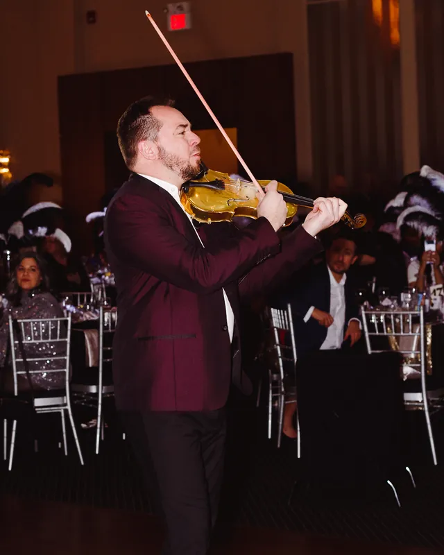 Violinist performing for guests at an evening celebration